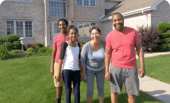 This is a photo of a happy family in front of their house